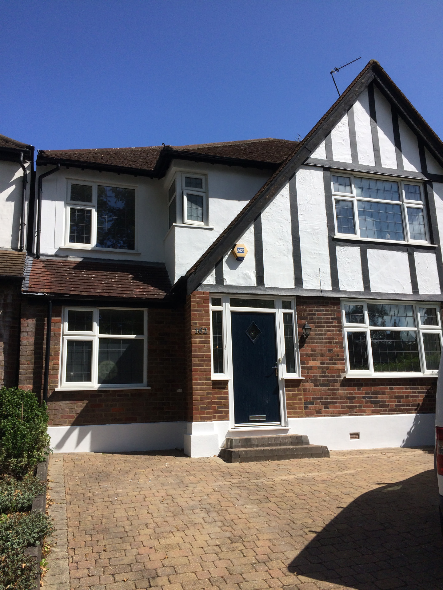Traditional Tudor style home with freshly painted white render and dark timber detailing